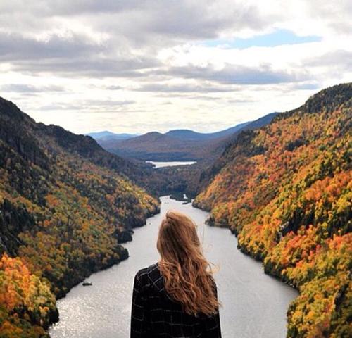 Women standing with open hair on top and between two rahua rainforest mountain valleys