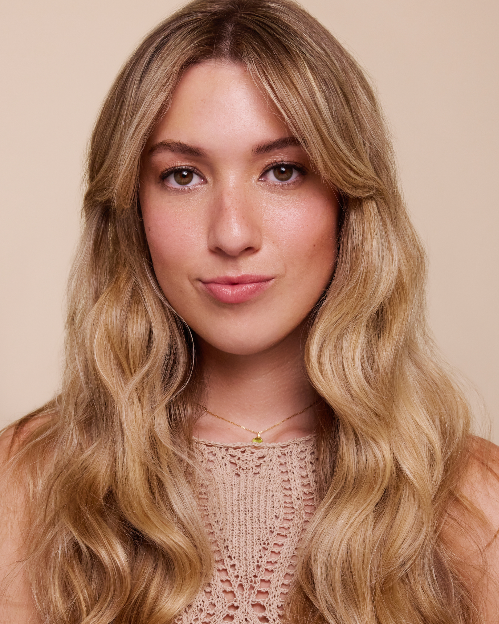 Woman with long, wavy blonde hair wearing a beige top against a beige background|variant:93-oz,16-oz,18-oz