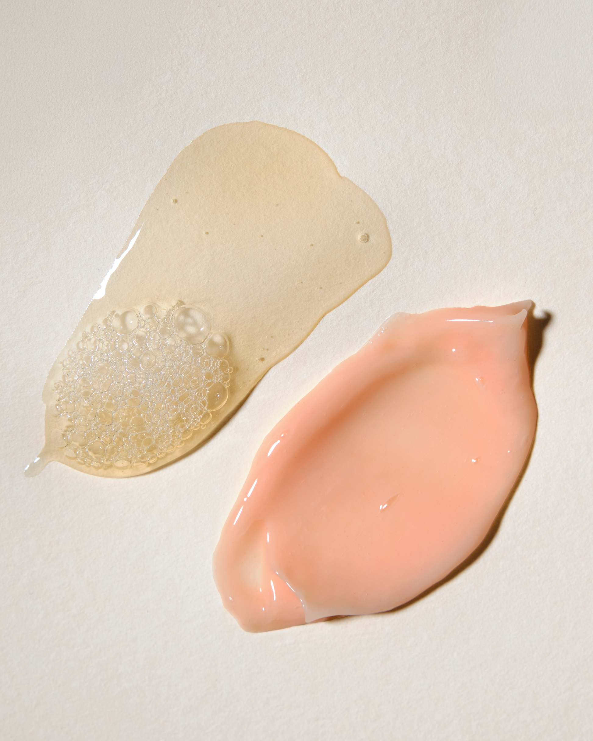 Two different colored cosmetic products on a light gray background|variant:93-oz,16-oz