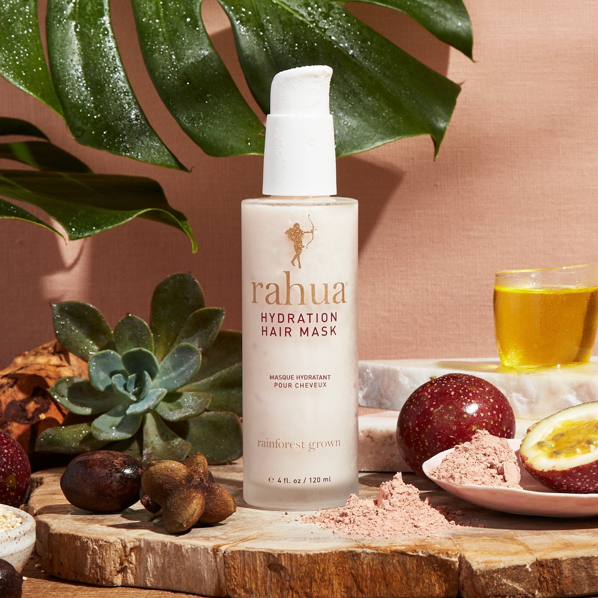 misted over glass bottle with white pump rahua hydration hair mask sitting on a stone slab with passion fruit mango rahua gold and succulent in the background|variant:4-oz